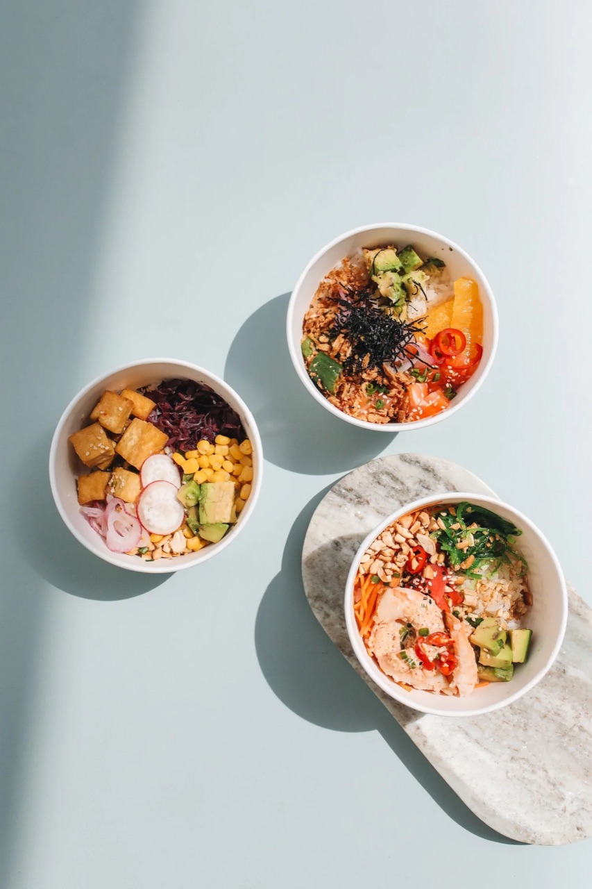 Three meal bowls seen from above: tofu, corn, radish, red cabbage, avocado and colourful vegetables
