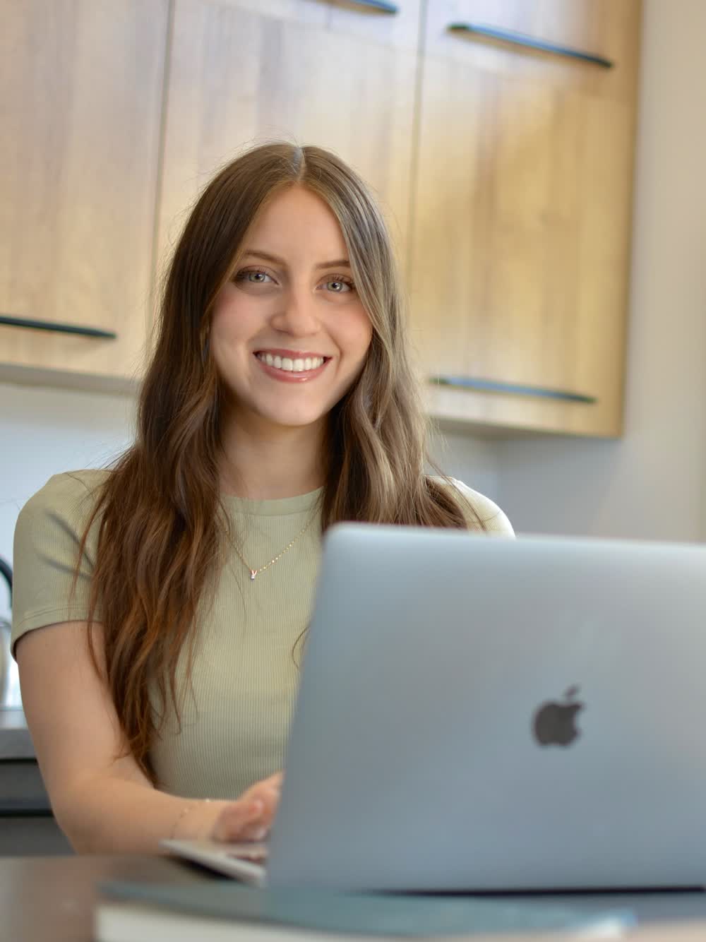 Martina, Registered Dietitian-Nutritionist, smiling at her laptop during an online consultation